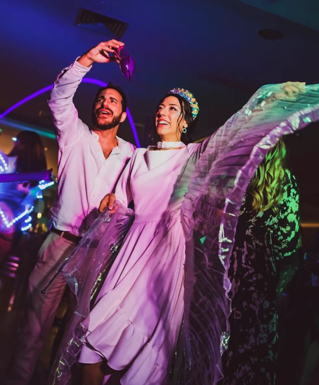Pareja con alas luminosas en evento
